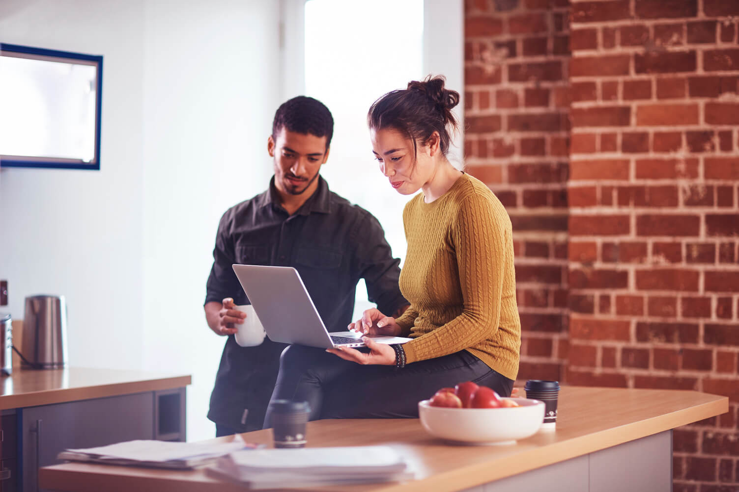 Couple looking at laptop in home.