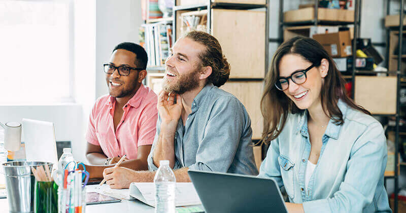 Business people using laptop looking away