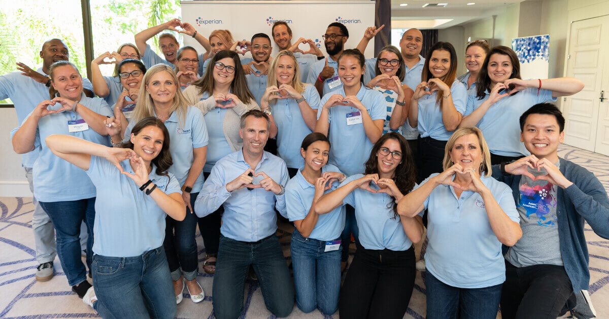 Group of Experian employees posing with hundreds of bags filled for a local non-profit