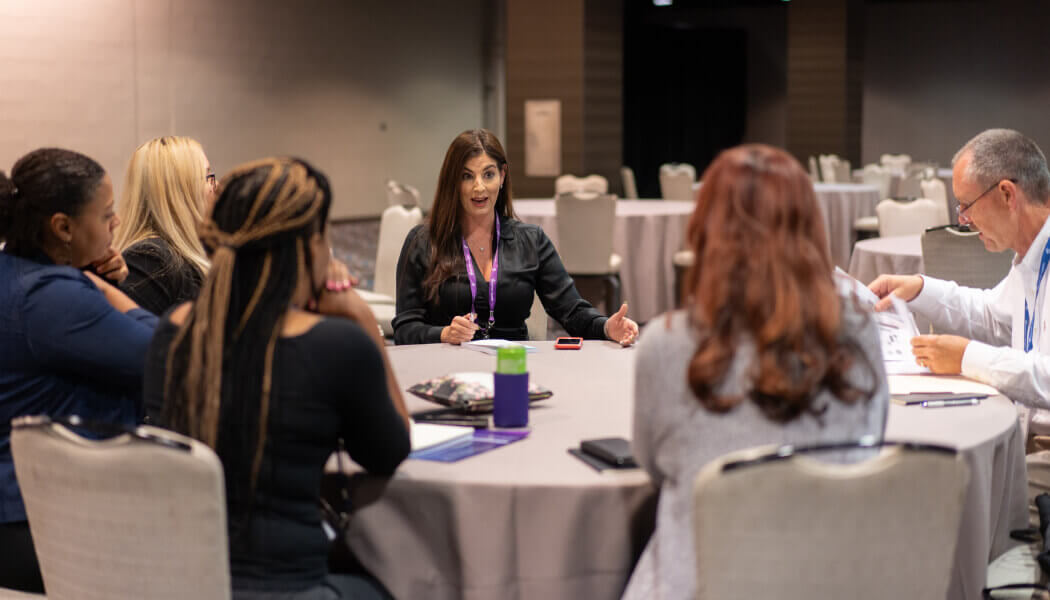 Experian employees talking with a female amputee around a white, circular table